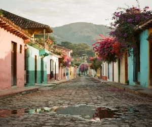 Rue pavée colorée bordée de bougainvilliers et montagnes