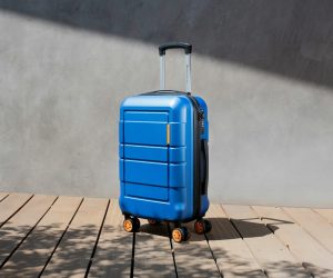 a blue suitcase sitting on top of a wooden floor
