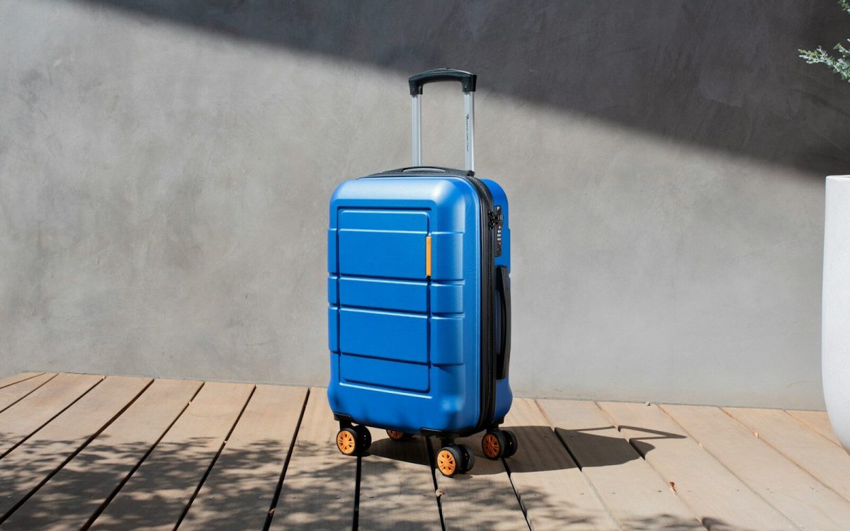 a blue suitcase sitting on top of a wooden floor