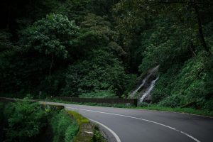 Route sinueuse en forêt tropicale avec cascade